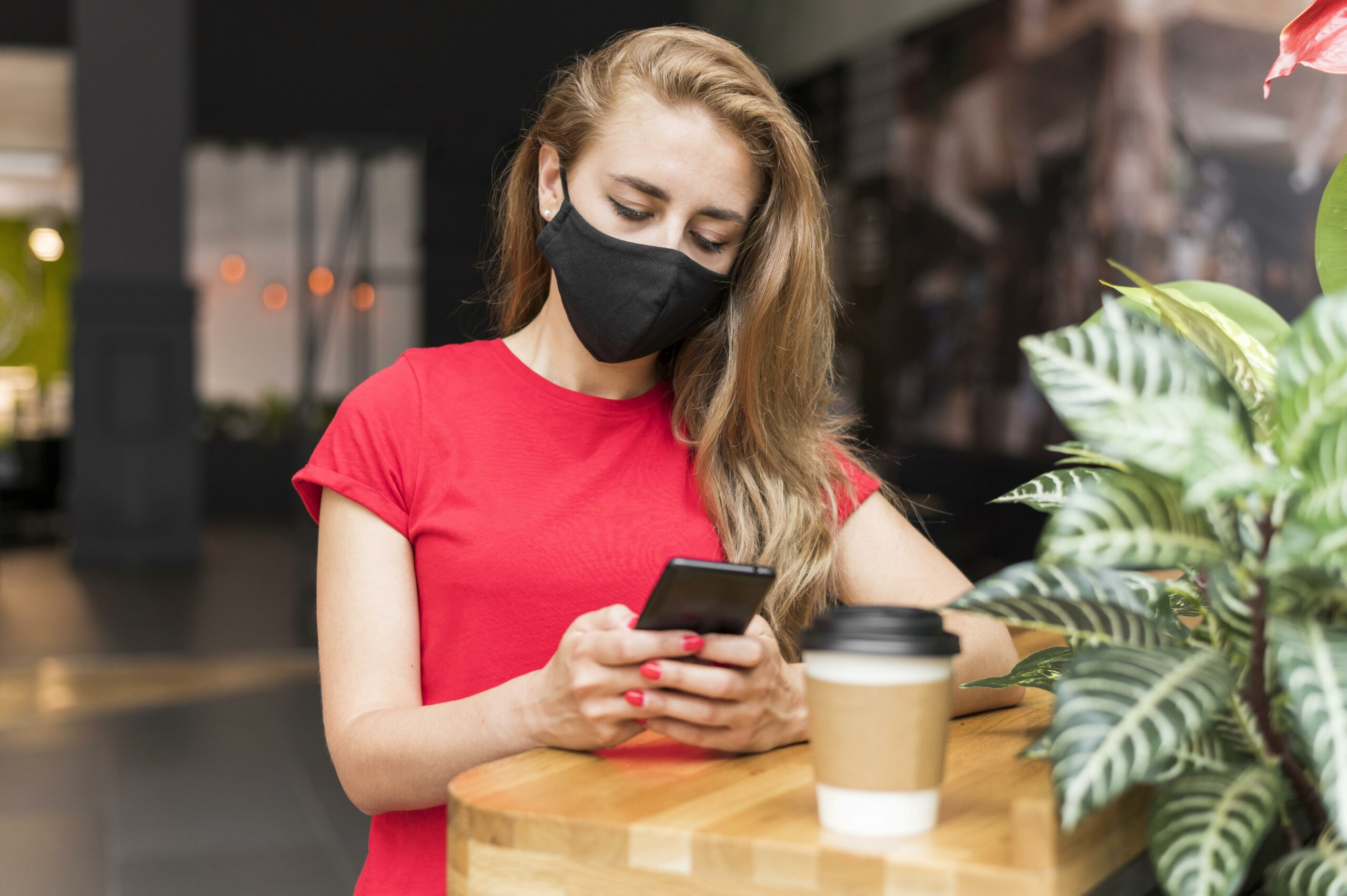 woman mall with mask checking mobile scaled - Home